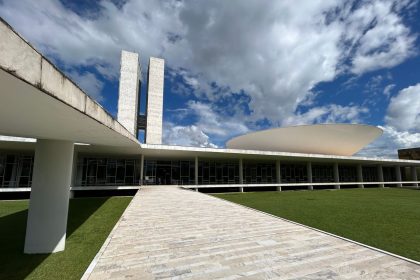 Vista externa do Congresso Nacional brasileiro sob um céu claro.