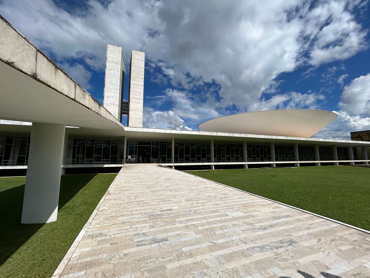 Vista externa do Congresso Nacional brasileiro sob um céu claro.