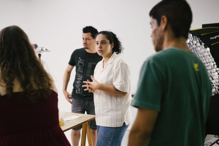 Equipe criativa reunida em um estúdio, discutindo ideias para projetos culturais.