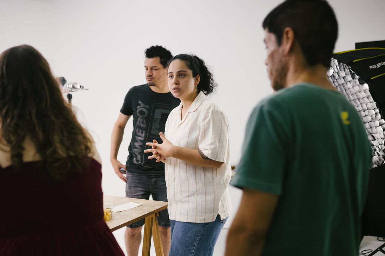 Equipe criativa reunida em um estúdio, discutindo ideias para projetos culturais.